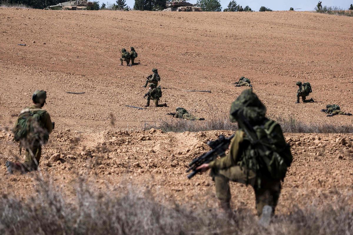 Soldados de Israel toman posiciones en Kfar Aza, al sur de Israel, en la frontera con la Franja de Gaza.