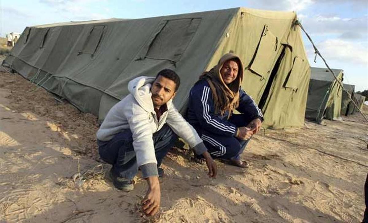 Refugiats egipcis arribats de Líbia descansen a la zona fronterera de Tunísia. Refugiats egipcis arribats de Líbia descansen a la zona fronterera de Tunísia.