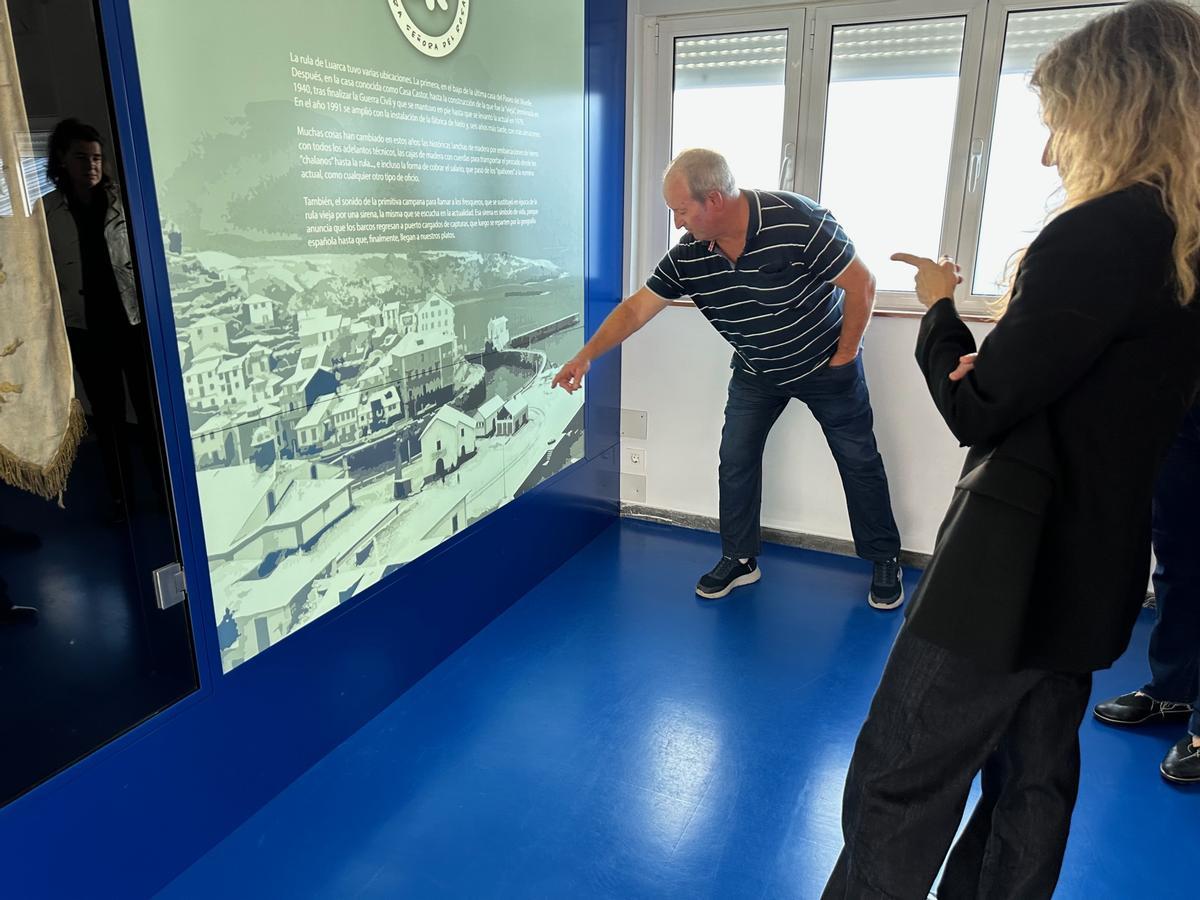 Amparo Merino observa una foto antigua de la cofradía siguiendo las explicaciones de Javier Lanza.