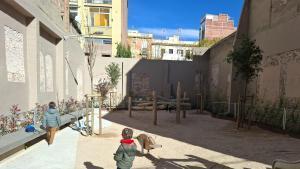 Parque infantil en un solar entre medianeras en Travessera de Gràcia