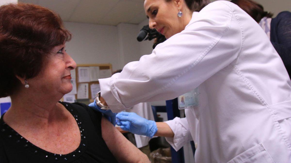 Una enfermera vacuna a una mujer contra la gripe.