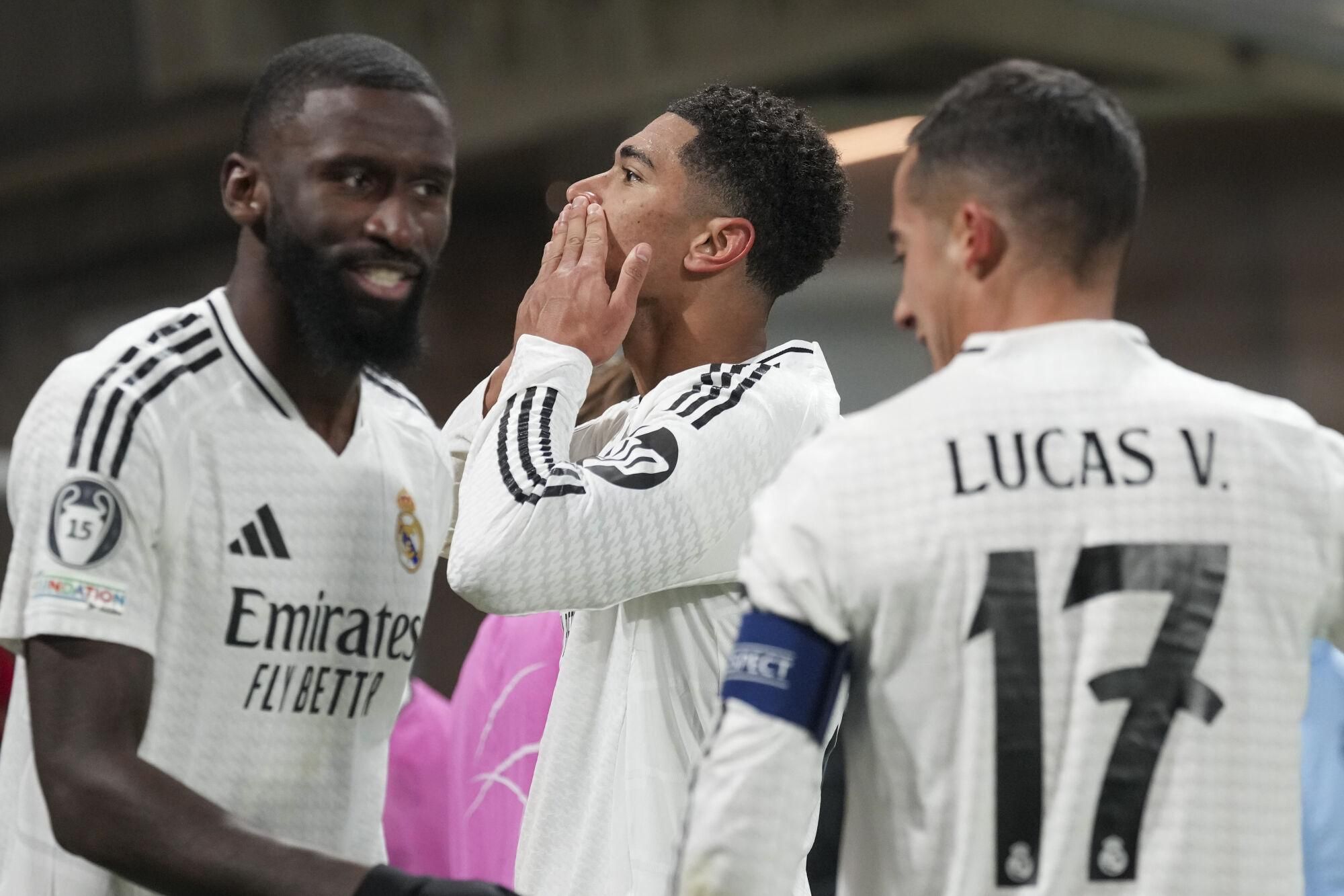 Real Madrid's Jude Bellingham, center, celebrates with his teammates after he scored his side's third goal during the Champions League opening phase soccer match between Atalanta and Real Madrid at the Bergamo's stadium, in Bergamo, Italy, Tuesday, Dec. 10, 2024. (AP Photo/Antonio Calanni). EDITORIAL USE ONLY / ONLY ITALY AND SPAIN