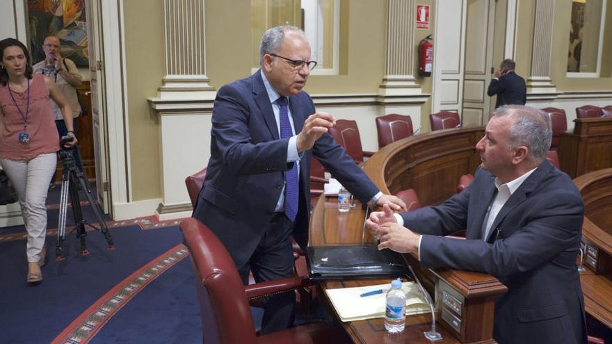 Casimiro Curbelo charla con Luis Campos en un pleno del Parlamento.