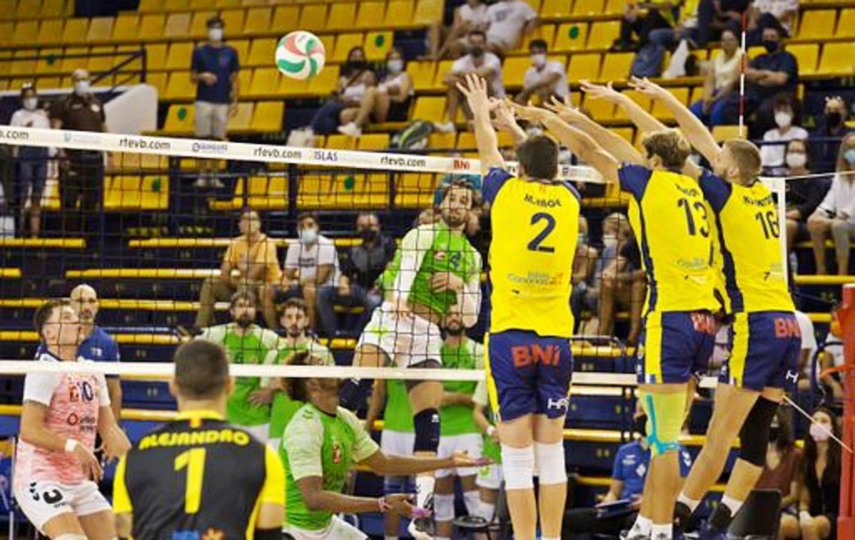 El receptor Juanmi González trata de superar el triple bloqueo del Club Voleibol Guaguas.