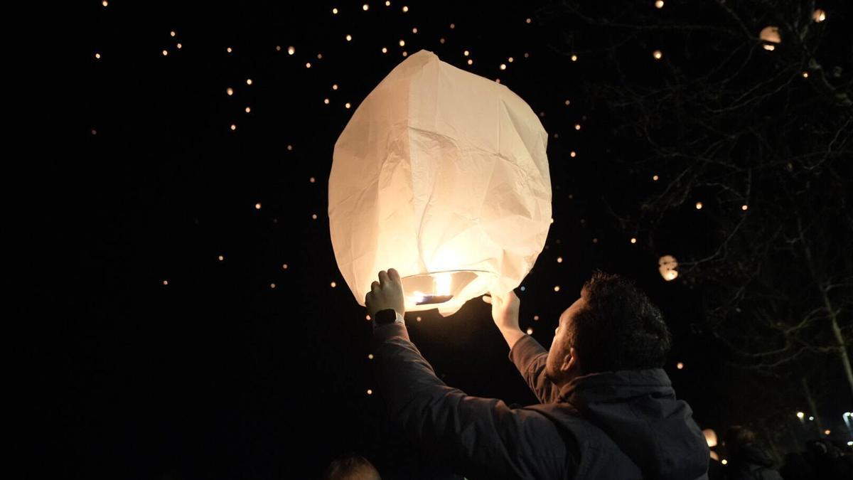 Un joven lanza un farolillo durante la Noche de los deseos de 2024 en Badajoz.