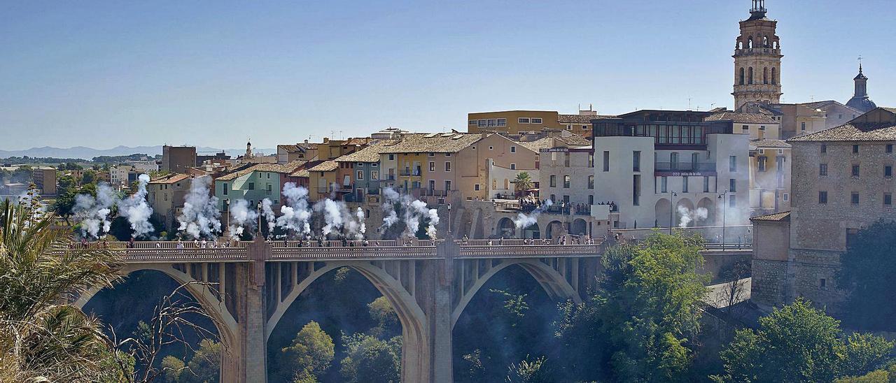 Ambaixada de Moros i Cristians sobre el puente de Santa María, con el barrio de la Vila y la iglesia de Santa María al fondo.