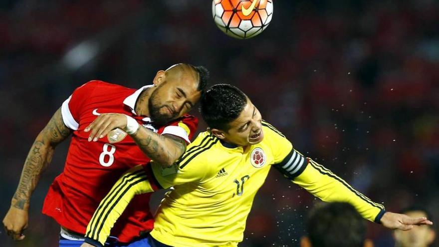El chileno Vidal y el colombiano James disputan el balón de cabeza.