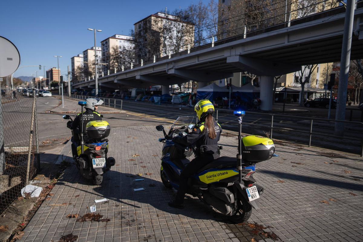 Dos agentes de la Guardia Urbana de Badalona ante el asentamiento bajo el puente de la C-31, el 30 de diciembre de 2025