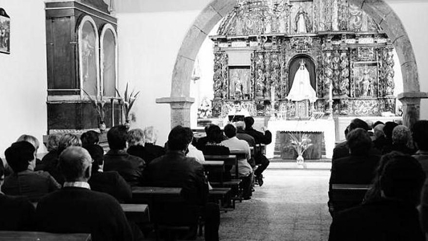 La remozada iglesia de Parlero, llena de fieles, durante la misa del sábado. Al fondo, el retablo del siglo XVIII que ha sido restaurado.