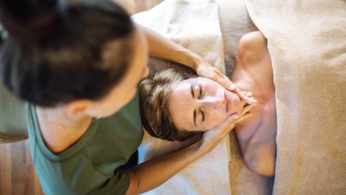 Una paciente recibe un masaje facial relajante.