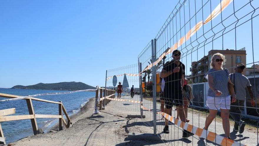 Imagen, ayer, de la zona vallada mientras los turistas pasan por el paseo.