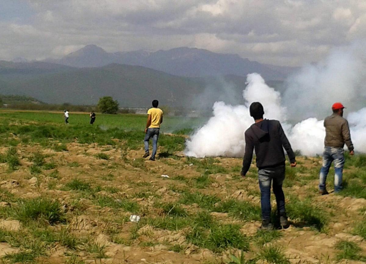 IDO103  Idomeni  Greece   10 04 2016 - A migrant tries to avoid tear gas smoke thrown by riot police officers of the Former Yugoslav Republic of Macedonia  FYROM  during a protest on the Greek side of the border  in the makeshift camp for refugees of Idomeni  northern Greece  10 April 2016  FYROM s police officers used tear gas to disperse migrants demanding the opening of the borders on the Greek side   Protestas  Grecia  EFE EPA STR BEST QUALITY AVAILABLE