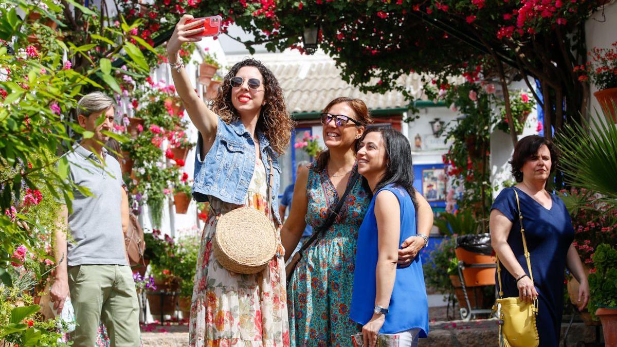 Tres mujeres se fotografían en un patio de Córdoba.