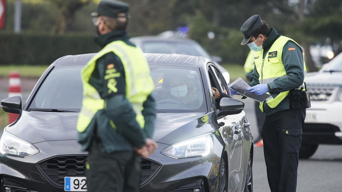 Un agente de la Guardia Civil pide la documentación a un vehículo durante un control efectuado en Laredo.