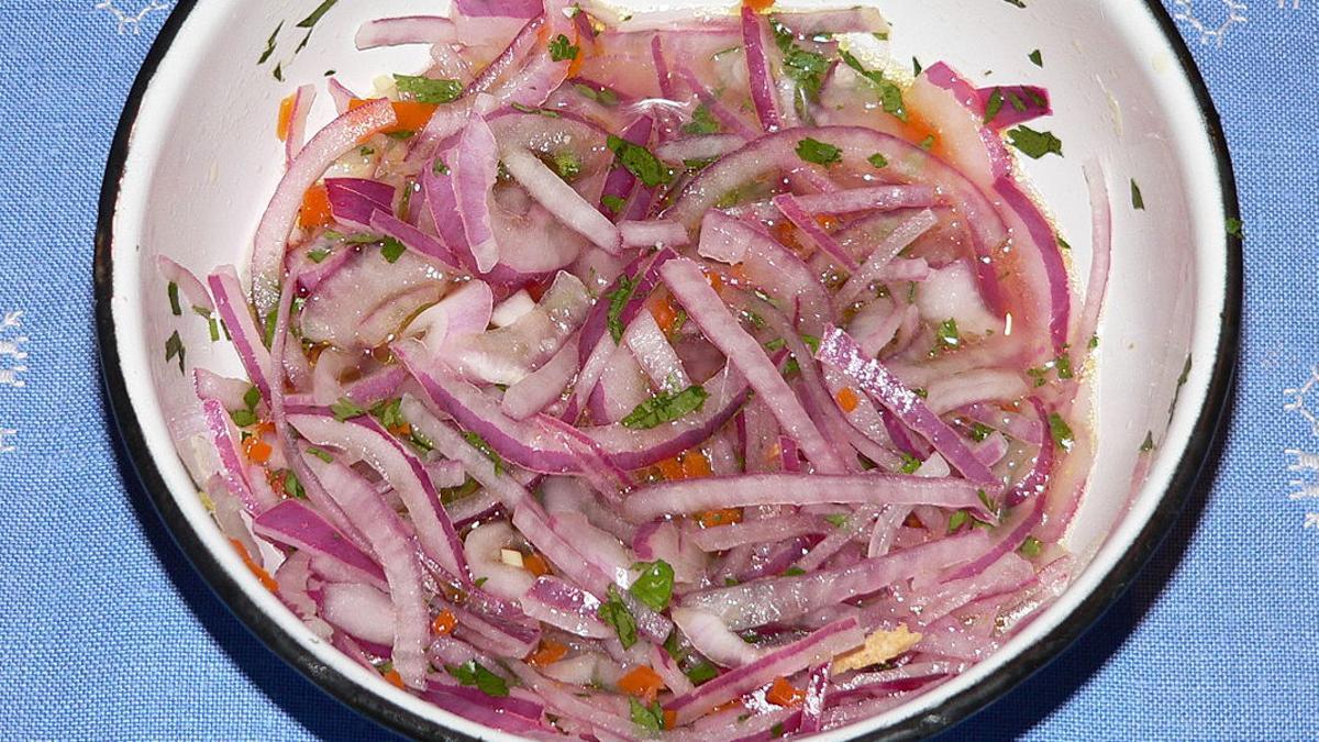 Sarza, una guarnición de cebolla, tomate, rocoto, vinagre y aceite con la que se acompaña las manitas de cerdo picante.