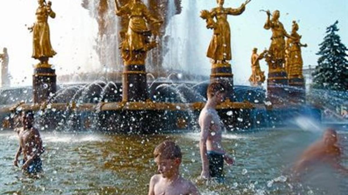 Un grupo de niños se refresca en una fuente pública en Moscú, el viernes.