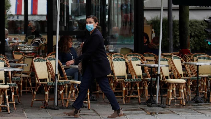 Una mujer camina frente a un restaurante en París.