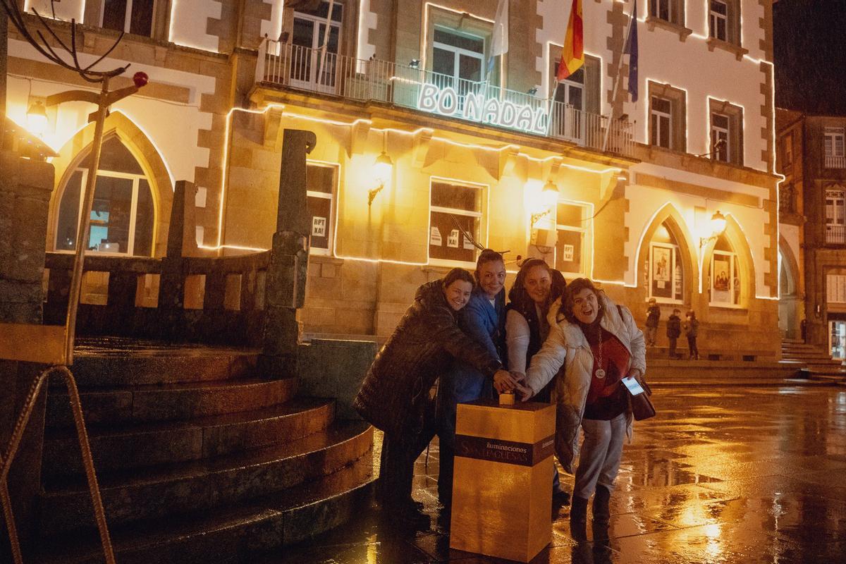 María Lago, segunda pola esquerda, e Caridad González, dereita, participando no acendido do alumeado de Nadal en Muros.