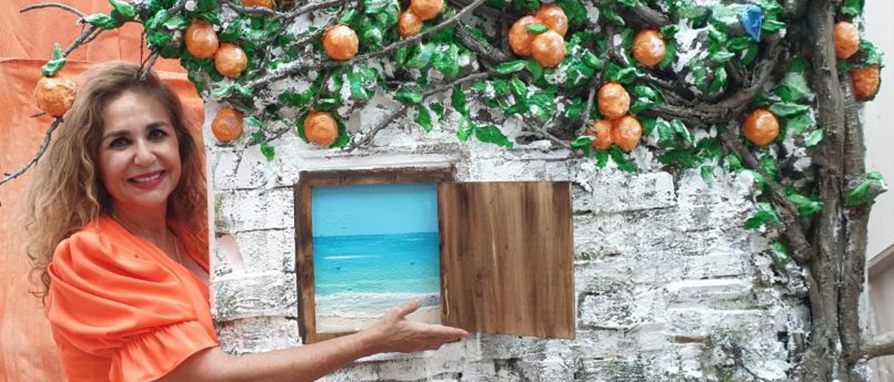 Marta Torres con uno de los cuadros de la muestra, ‘Naranjo con ventana junto al mar’.  |  FRAN CUEVAS