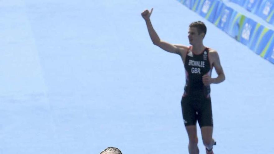 Alistair Brownlee cruza la línea de meta mientras su hermano recorre los últimos metros. // Efe