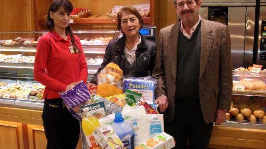 La encargada del Alimerka, a la izquierda, entrega su premio de 500 euros en compras a Vicenta García Prieto, de Oviedo, a quien acompaña su marido, Secundino Carballo. | lne