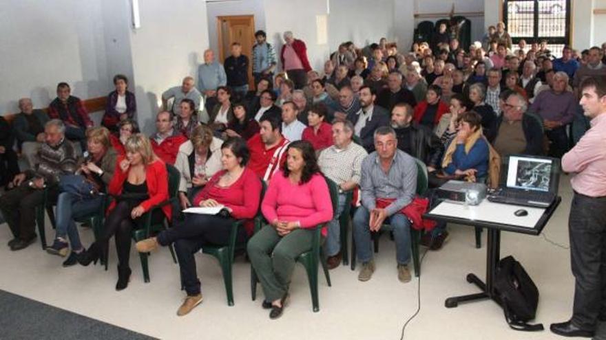 El concejal de Rural, Ramiro Gestido (a la derecha), expone el proyecto ante la asamblea de vecinos reunida en San Xulián.  // Santos Álvarez