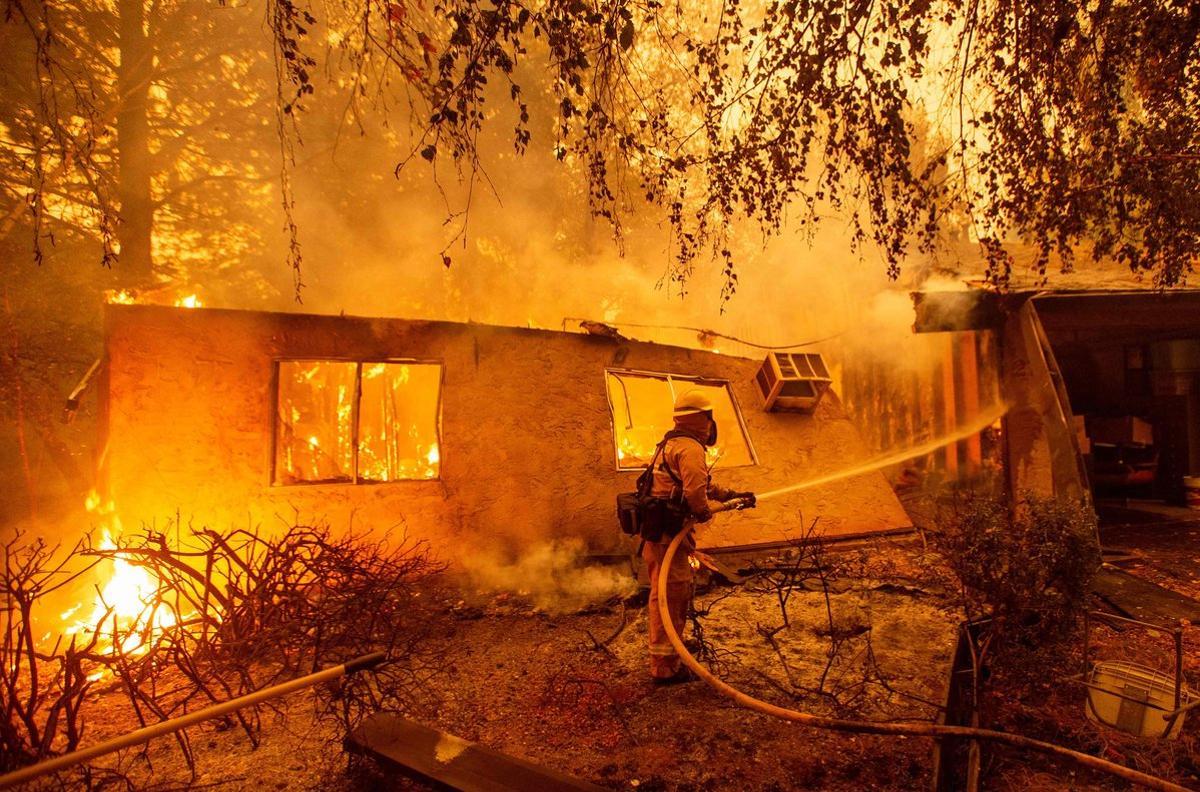 TOPSHOT - Firefighters battle flames at a burning apartment complex in Paradise, north of Sacramento, California on November 09, 2018. - A rapidly spreading, late-season wildfire in northern California has burned 20,000 acres of land and prompted authorities to issue evacuation orders for thousands of people. As many as 1000 homes, a hospital, a Safeway store and scores of other structures have burned in the area as the Camp fire tore through the region. (Photo by Josh Edelson / AFP)