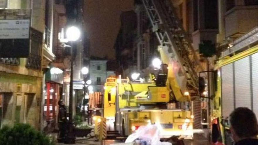 Labores de extinción del fuego ocasionado en un edificio de la calle de la Fruta, ayer, poco antes de la medianoche.