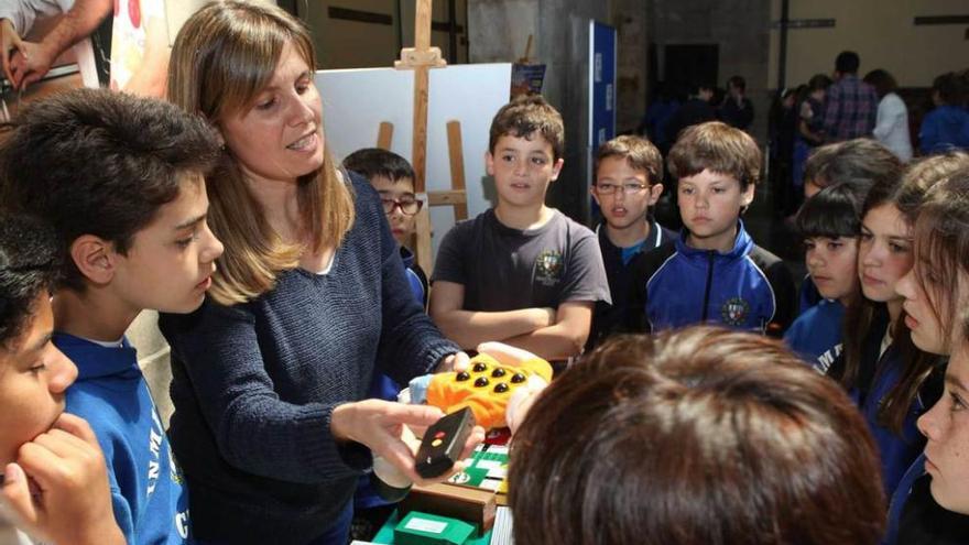 Una de las responsables muestra a los escolares algunos instrumentos para facilitar la vida diaria a los ciegos.