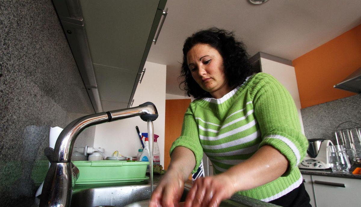 Una trabajadora del hogar friega los platos en un domicilio durante su jornada laboral.