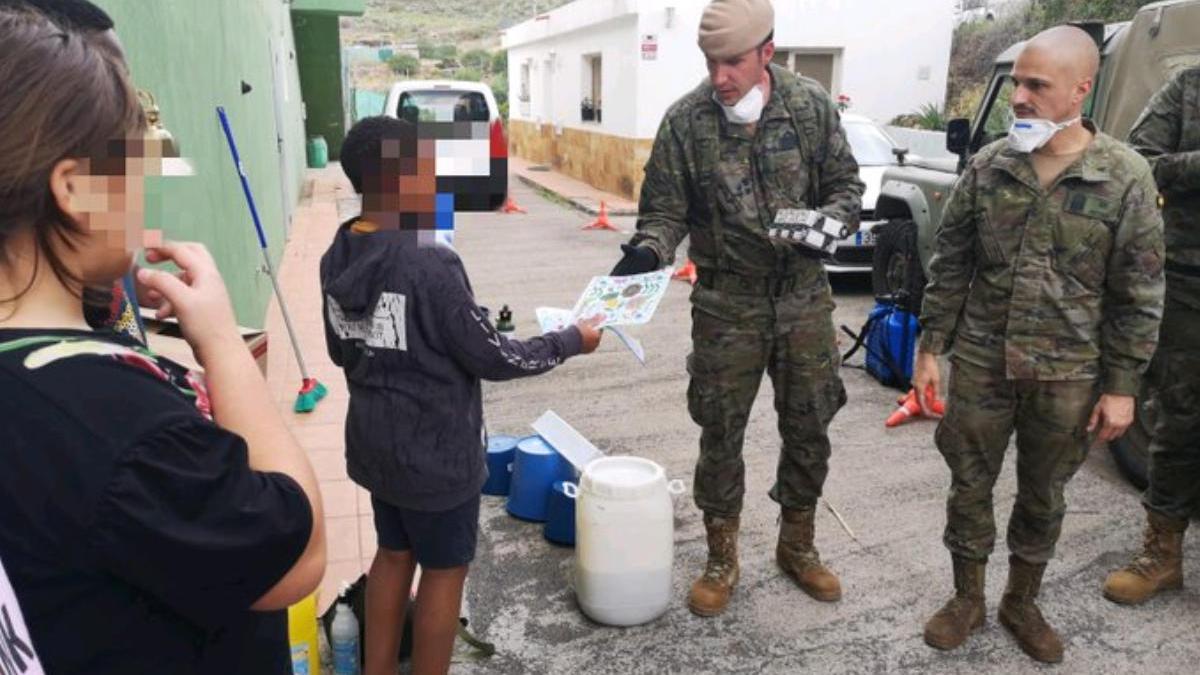 Un niño entrega un dibujo a un efectivo de la UME