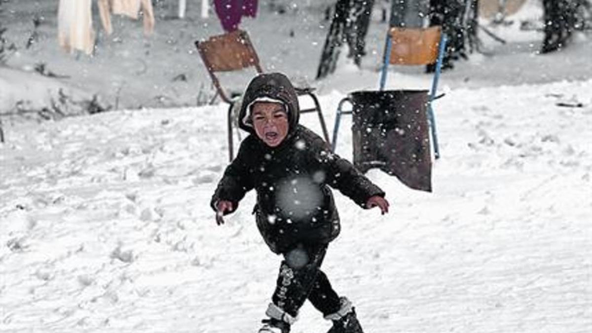 Un niño sirio, en un campo de refugiados lleno de nieve cerca de Atenas.