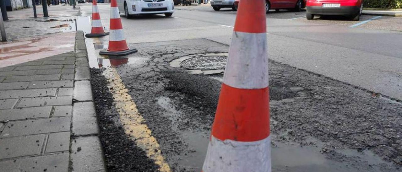 Conos para señalizar un bache en la avenida de Los Telares.