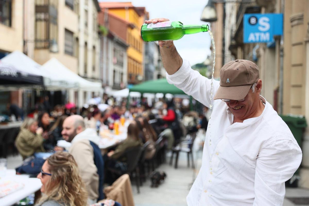 Un vecino escanciando sidra.