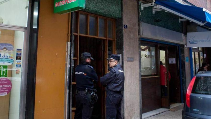 Dos policías, ante el portal del edificio donde residía Amador Suárez.