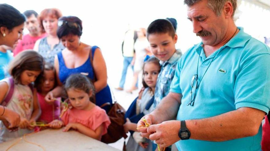 Manuel Antonio Rodríguez enseña a hacer nudos a varios niños.