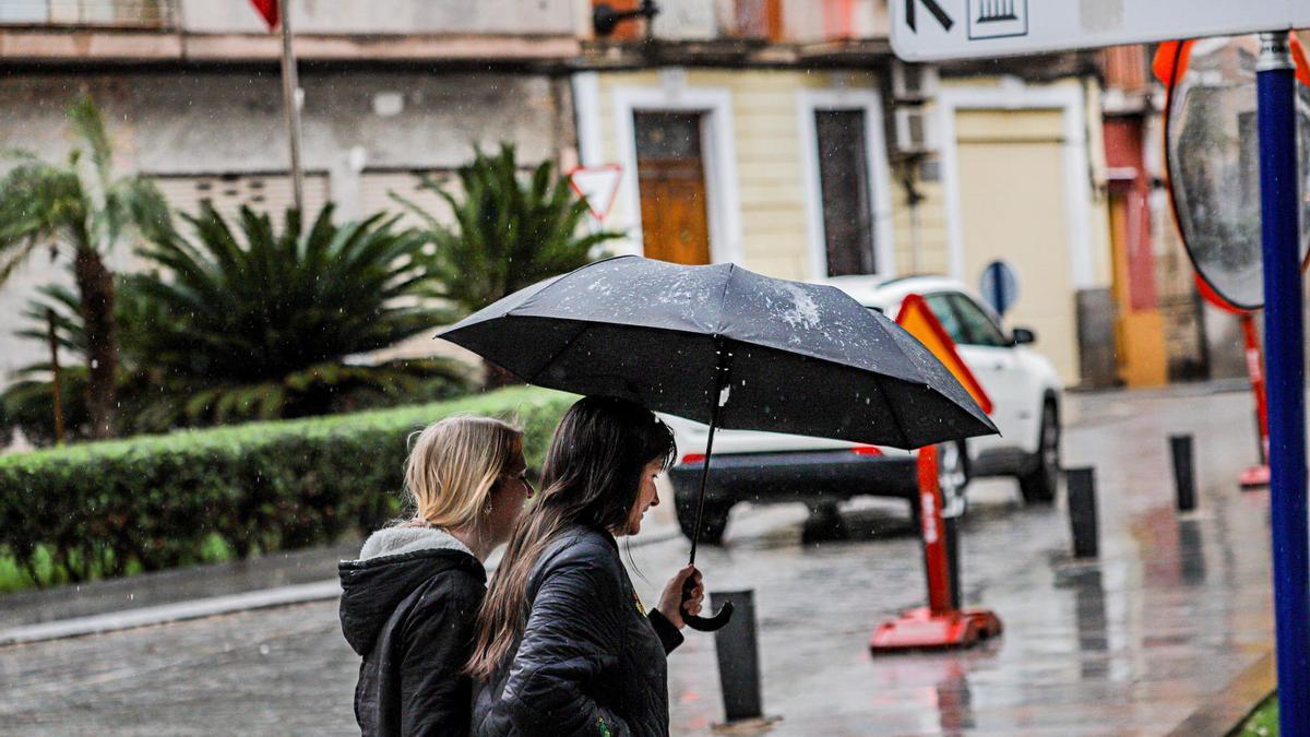 Dos mujeres bajo la lluvia en la gota fría que cayó en la Vega Baja en 2022