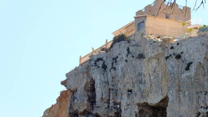 Vivienda colgada del acantilado. Parte de su terraza se ha desmoronado.