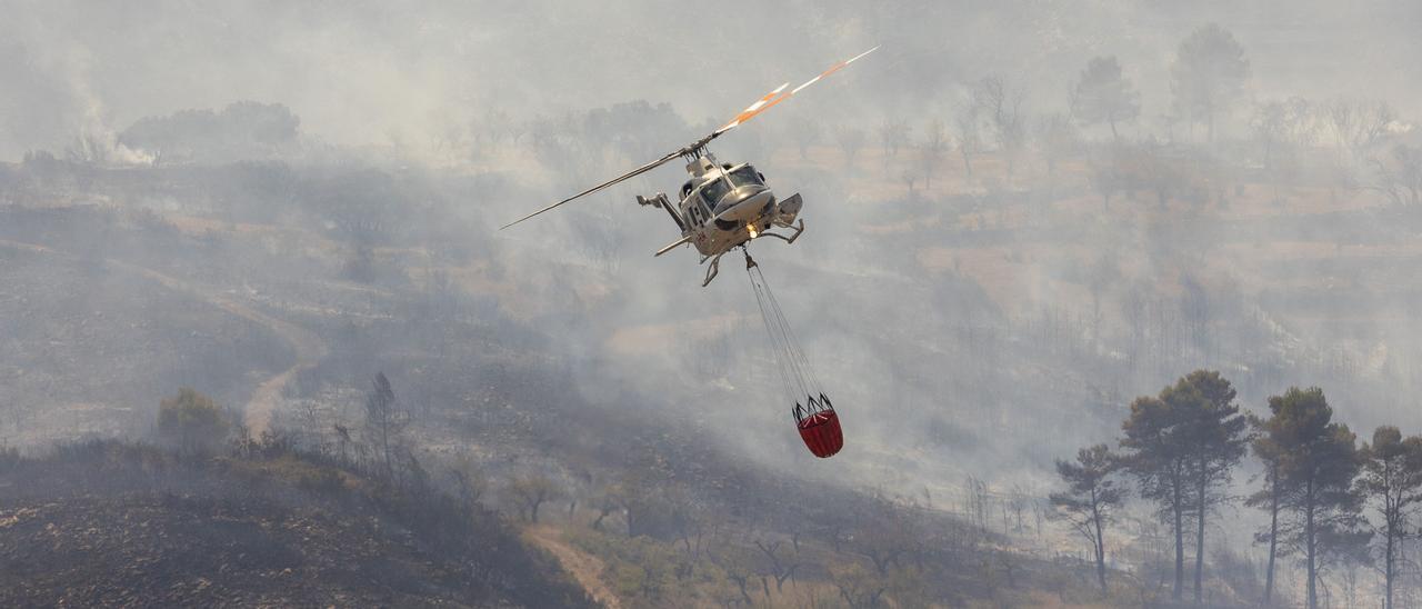 Un helicóptero trata de apagar las llamas del macroincendio forestal  de Bejís que afecta ya a un perímetro de unos 135 kilómetros.