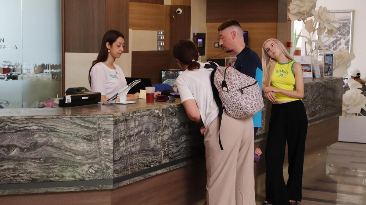 Uns turistes són atesos a la recepció d’un hotel, en una imatge d’arxiu.