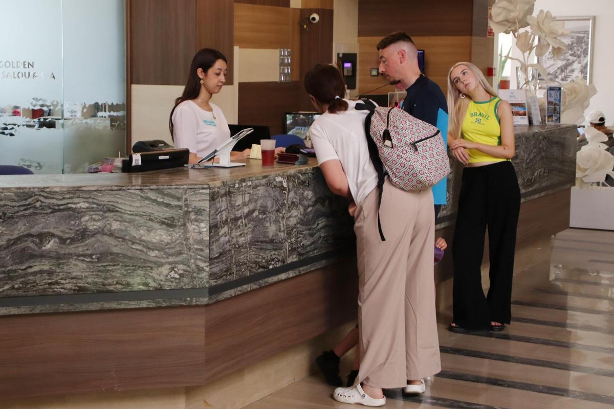 Uns turistes són atesos a la recepció d’un hotel, en una imatge d’arxiu.
