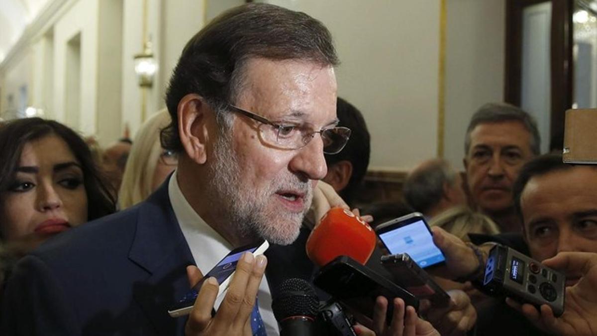 El presidente del Gobierno, Mariano Rajoy, atiende a los medios en los pasillos del Congreso.