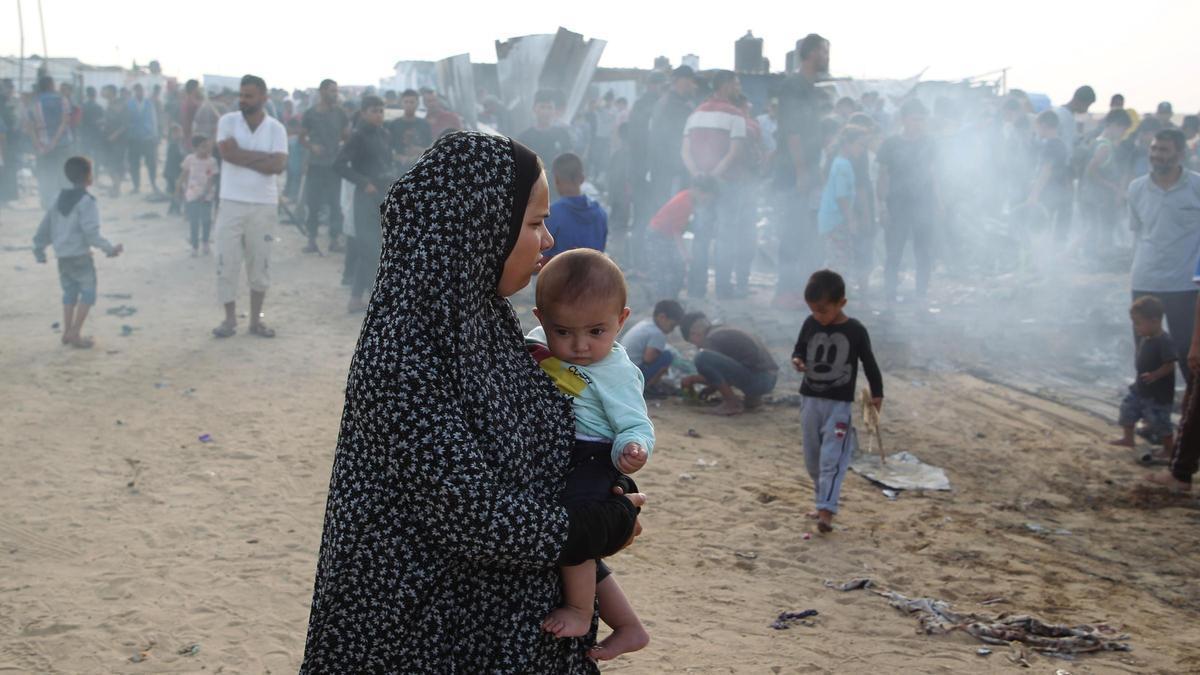 Una mujer observa la desolación tras el ataque al campo de refugiados de Rafah.