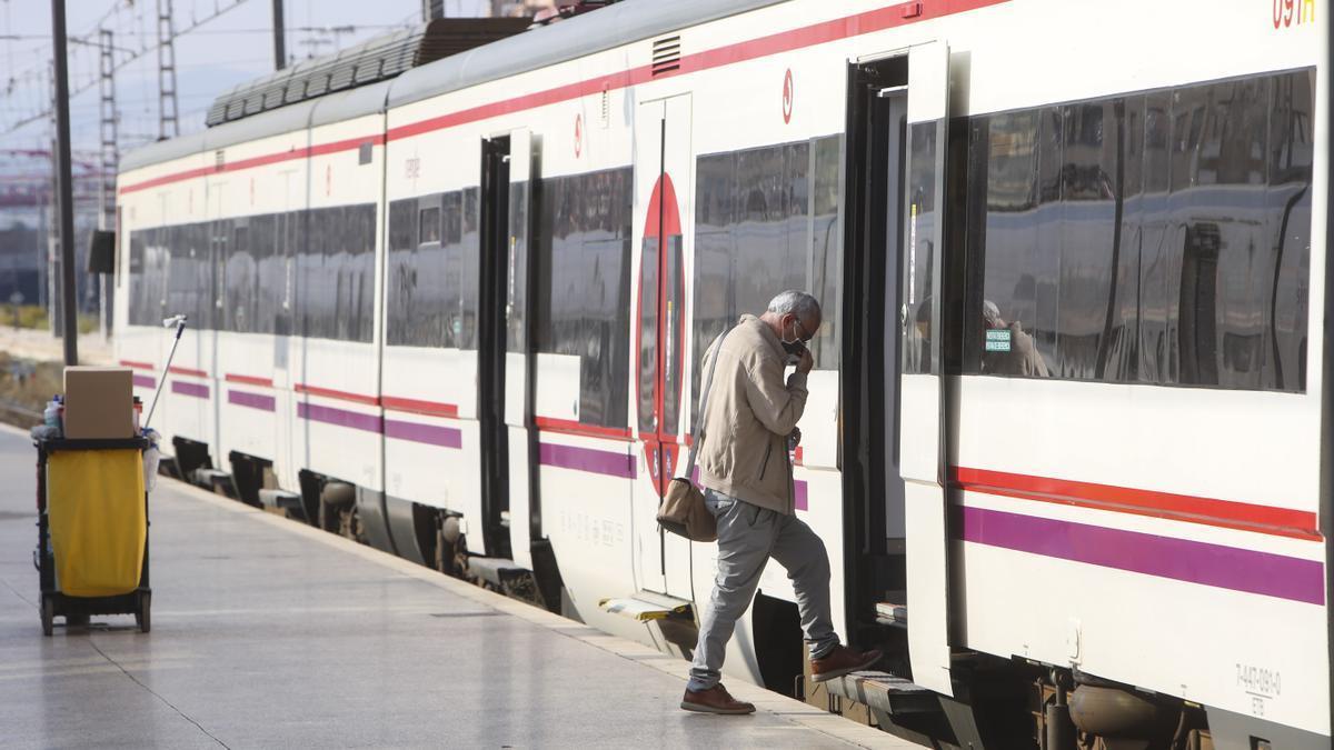 Un pasajero se sube a un tren de cercanías en la estación de Alicante.