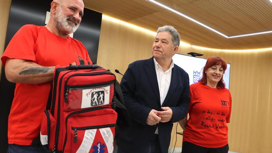 Fran Pérez y una voluntaria de Asampo flanquean al alcalde, esta mañana, en la presentación de la marcha nocturna solidaria.