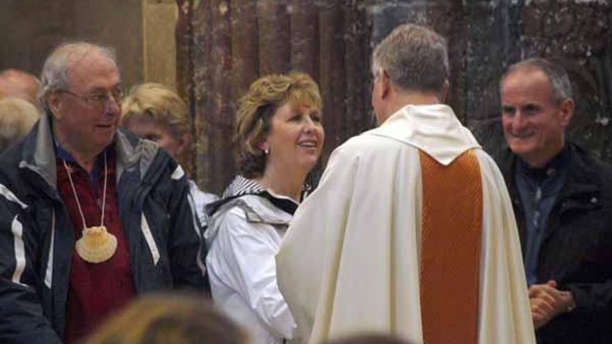 Mary McAleese saluda a un miembro de la curia a su llegada a la catedral de Santiago.