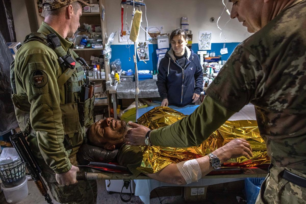 Los médicos militares preparan a un soldado ucraniano herido para ser transportado a un hospital, en un hospital de campo de primera línea cerca de Popasna, región de Lugansk, Ucrania oriental.