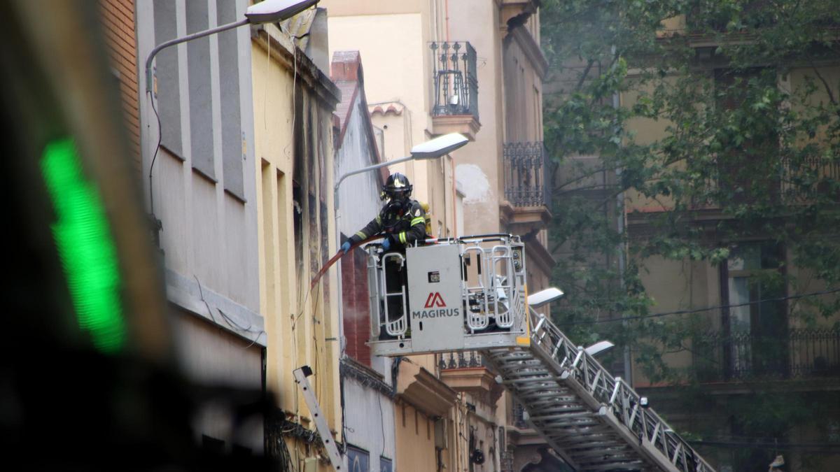Un bomber treballant al carrer Venero, on hi ha hagut una explosió