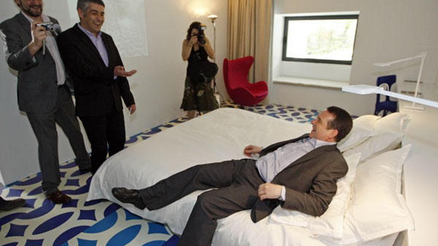 El alcalde Abel Caballero prueba la cama del montaje artístico del &quot;Hotel MARCO&quot;.  // Marta G. Brea