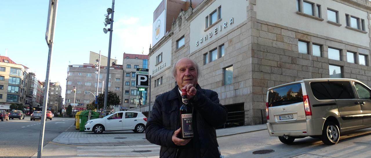 José Fernández Vidal posa con la botella delante del edificio que fuera sede de la bodega. / P.P.
